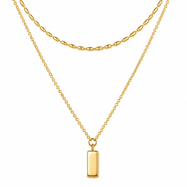 Clean product image of a minimalist gold bar pendant necklace with layered chain design displayed on a white background.